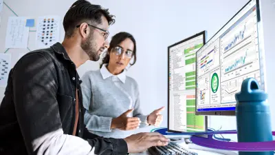 コンピュータの前に座ってETASソフトウェアを使用する2人の開発者