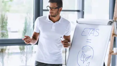 un homme debout devant un tableau blanc représentant la valeur de la durabilité pour ETAS