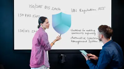 The image depicts two colleagues discussing about cybersecurity compliance and standards