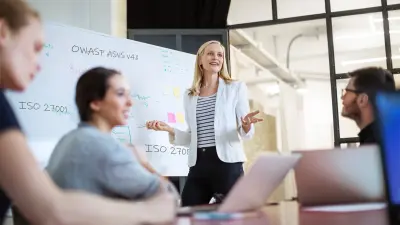 L'équipe discute et la femme se tient devant le flipchart