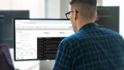 Un homme regarde un tableau de bord sur l'écran d'un PC.