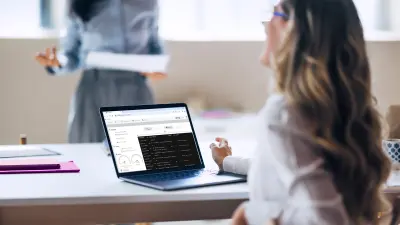 Femme assise avec un ordinateur portable lors d'une formation sur les tests de fuzz organisée par ETAS