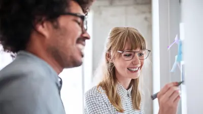 Groupe de professionnels divers engagés dans une discussion collaborative autour d'une table haute symbolisant l'inclusion et le travail d'équipe chez ETAS.