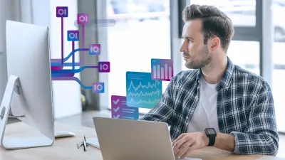 Ein Ingenieur arbeitet am Computer, auf dessen Bildschirm Datenströme, Diagramme und Workflow-Visualisierungen zu sehen sind.